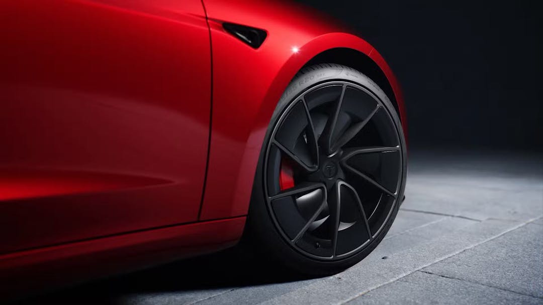 2024 Tesla Model 3 Performance in red zoomed in on front wheel