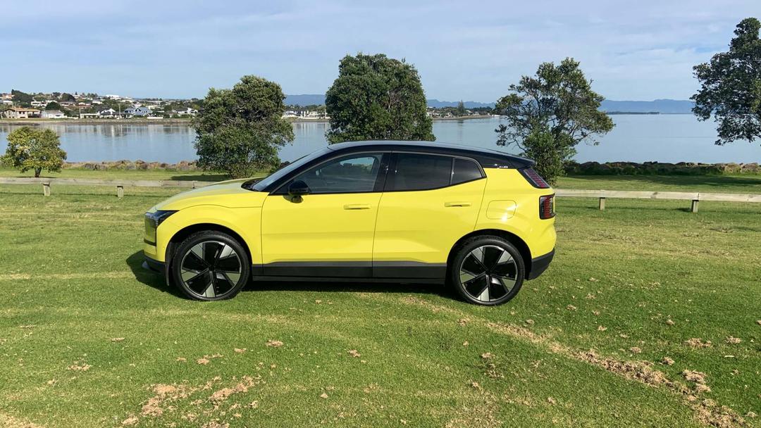 Volvo EX30 in moss yellow side view parked