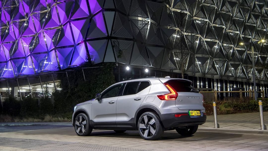 Volvo XC40 Recharge in front of purple building at night rear view