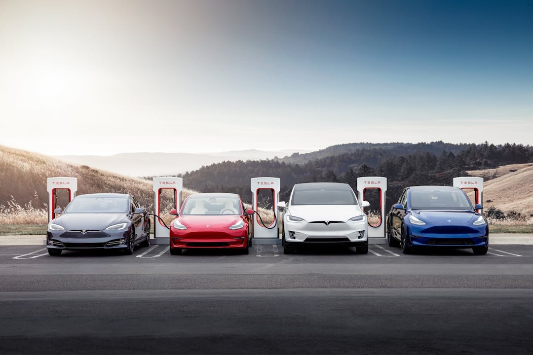 Four Tesla electric cars charging at Tesla Supercharging station