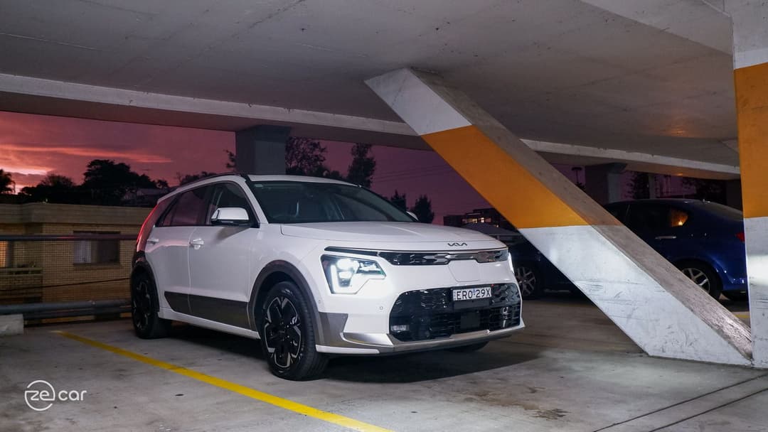 Kia Niro EV with headlights on in orange car park