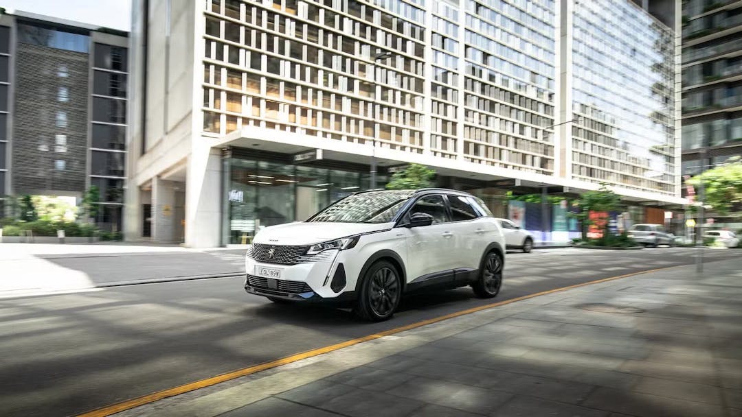 Peugeot 3008 in white driving in the city