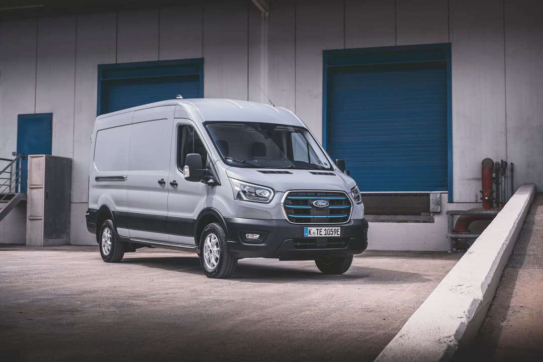 Silver Ford E-Transit commercial van in front of loading dock Silver Ford E-Transit commercial van in front of loading dock