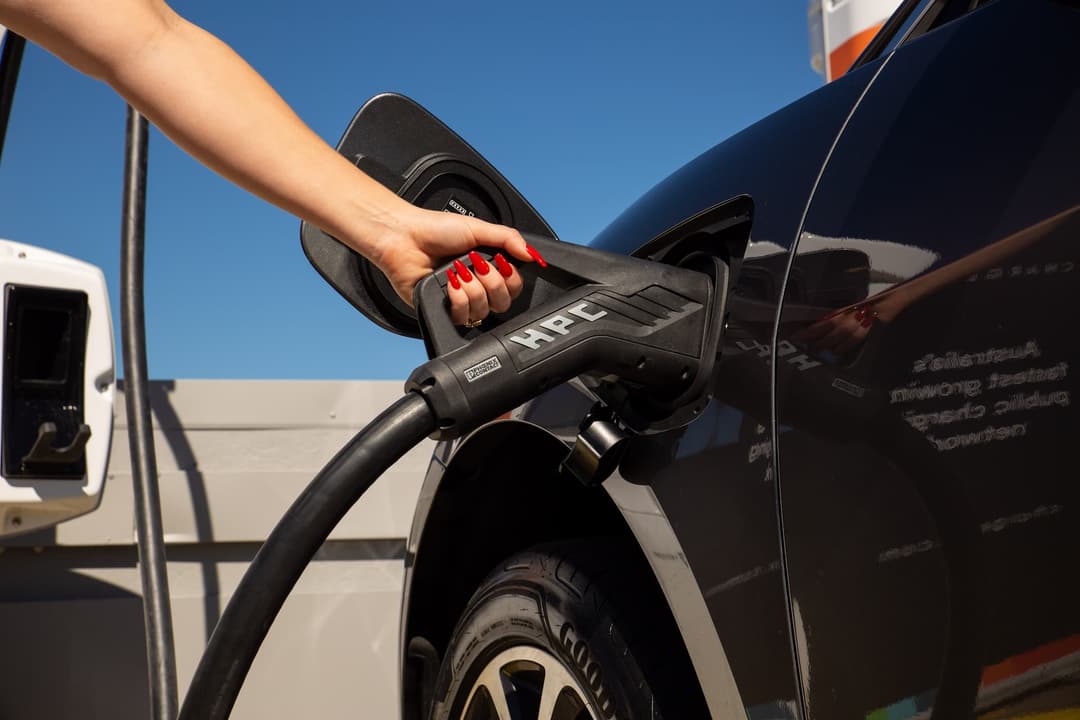 Person holding ultra rapid charging cable into electric car Person holding ultra rapid charging cable into electric car