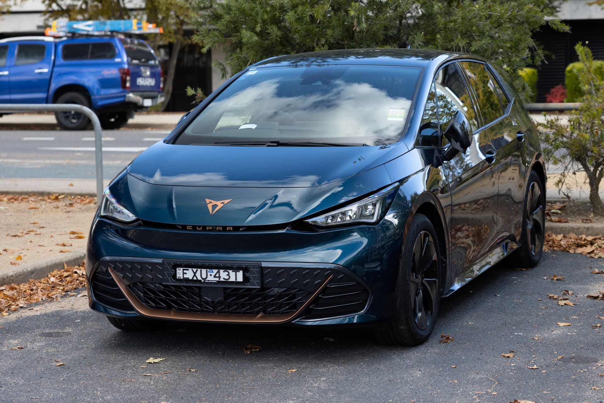 Aurora Blue Cupra Born parked in front of blue ute Aurora Blue Cupra Born parked in front of blue ute