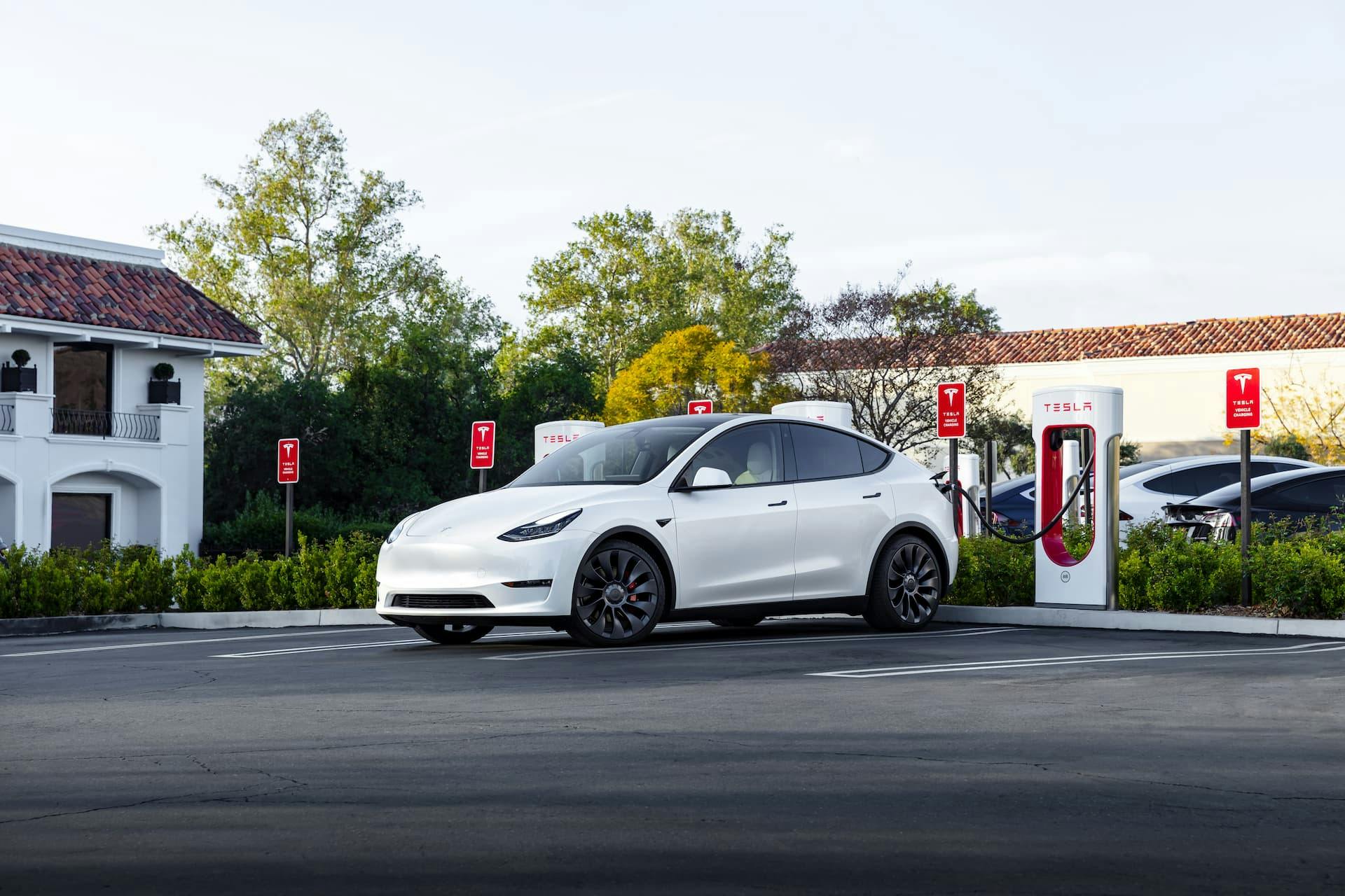 White Tesla Model Y Supercharging