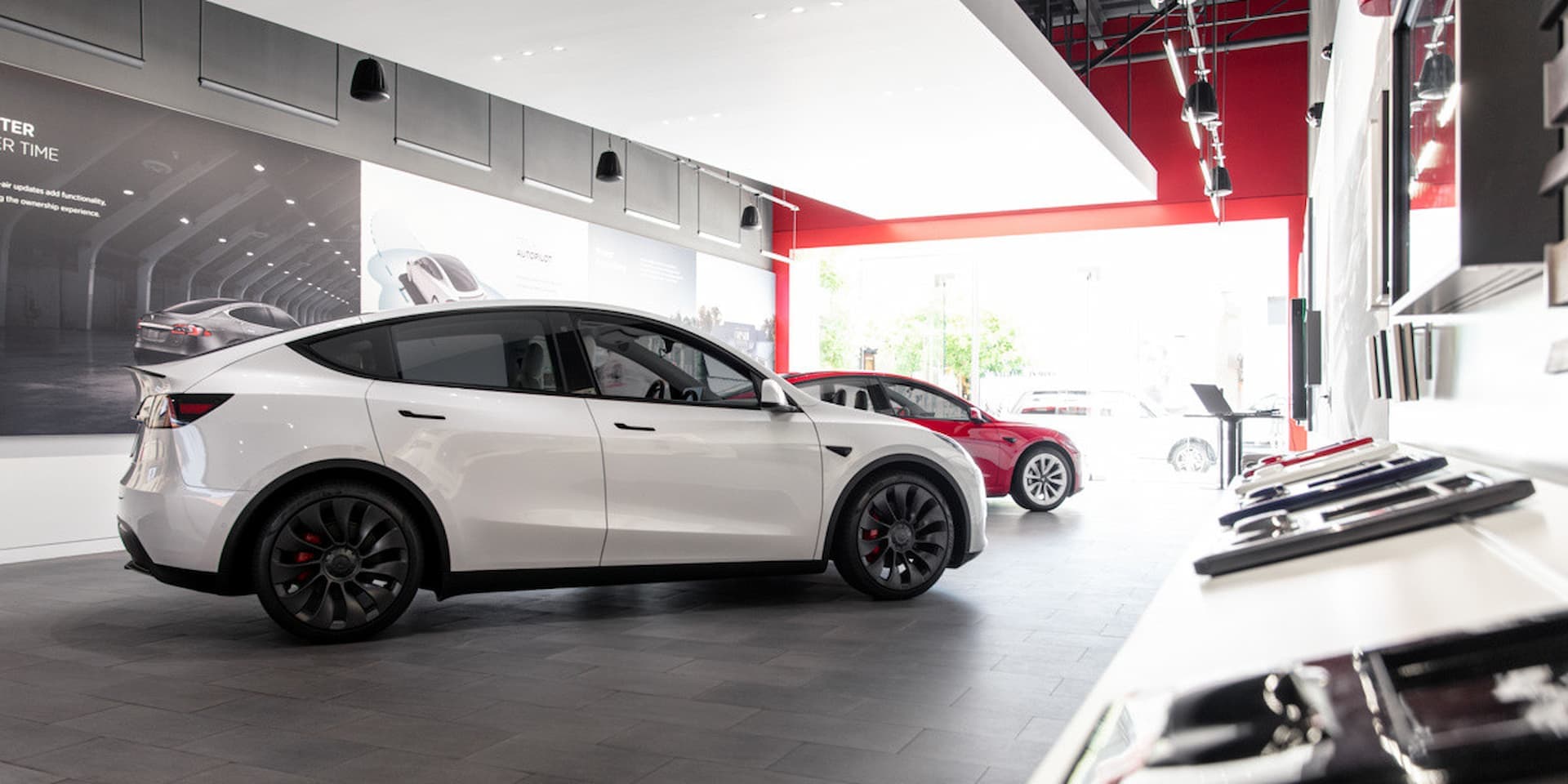 Tesla Model Y in front of Model 3 in Tesla showroom Tesla Model Y in front of Model 3 in Tesla showroom