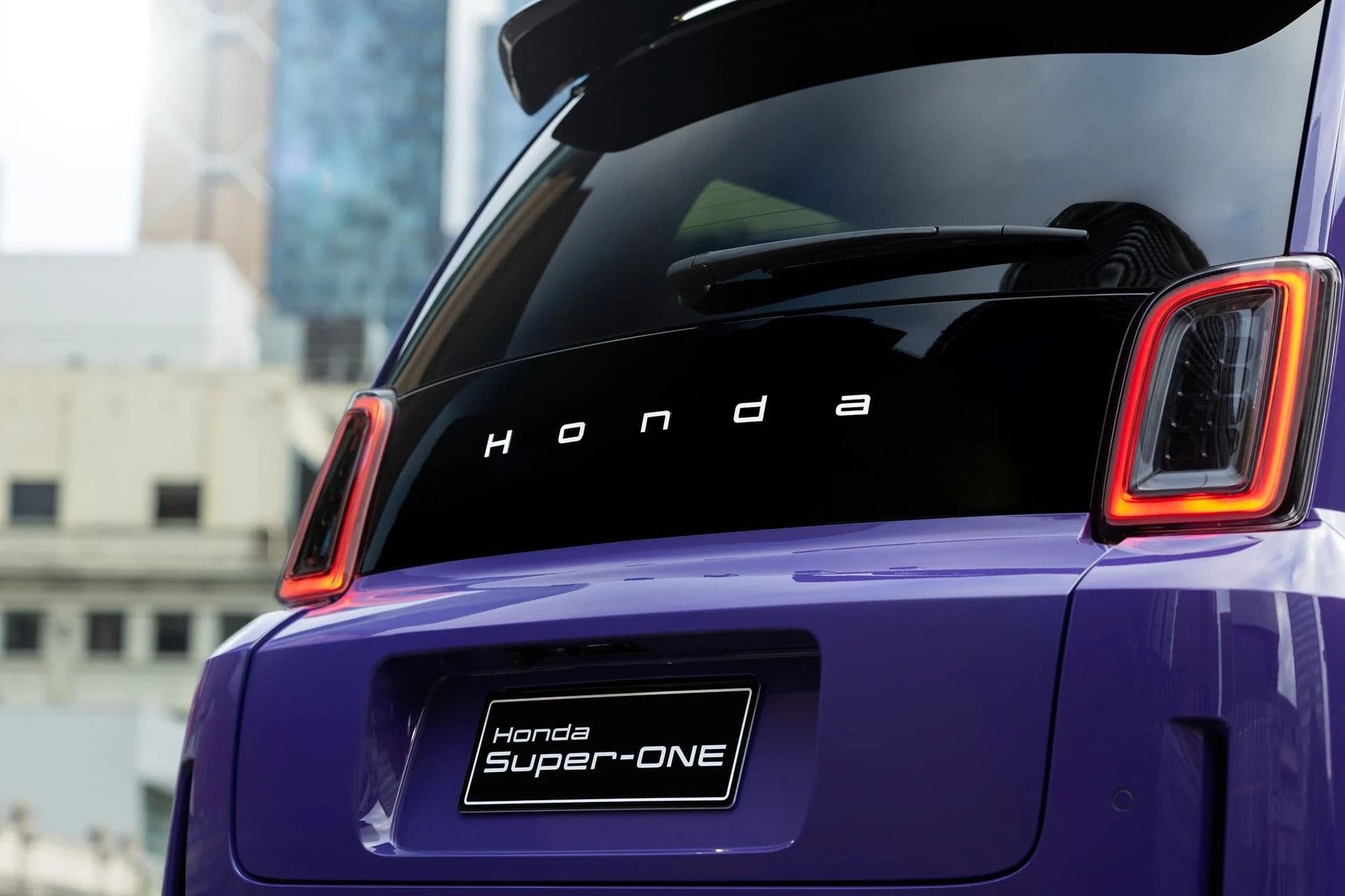 Rear view of a purple Honda Super-One showing LED taillights and Honda lettering across the rear window Rear view of a purple Honda Super-One showing LED taillights and Honda lettering across the rear window