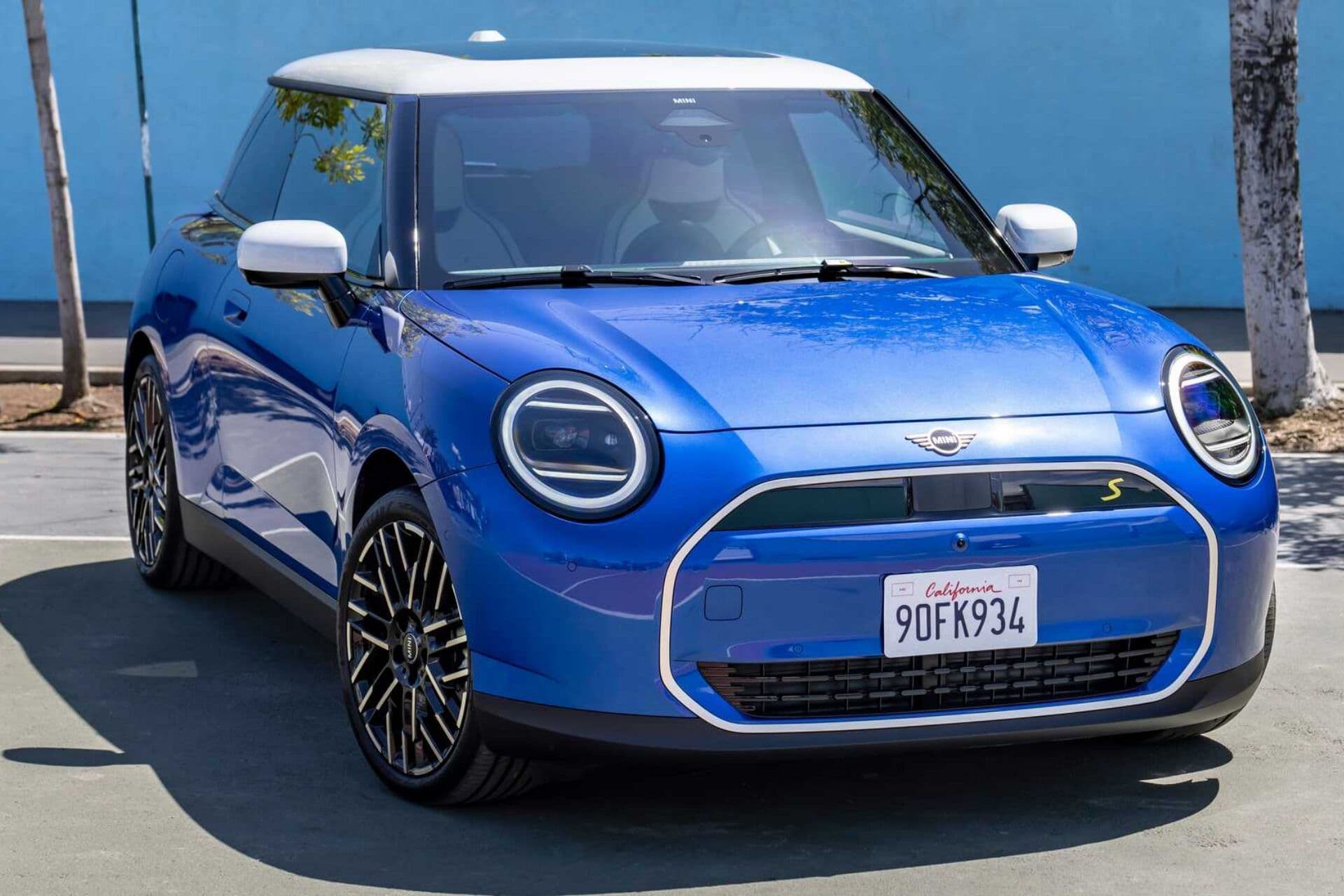 Mini Cooper EV in blue three quarter view parked on street Mini Cooper EV in blue three quarter view parked on street
