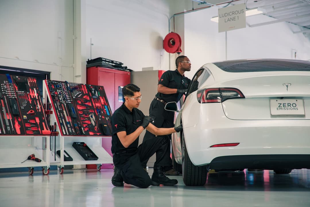 Two men inspect and service Tesla Model 3 Two men inspect and service Tesla Model 3