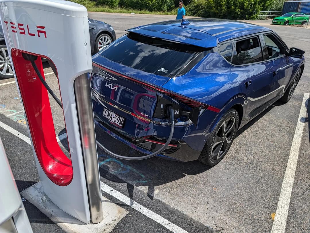 Tesla EV near a charging station Tesla EV near a charging station