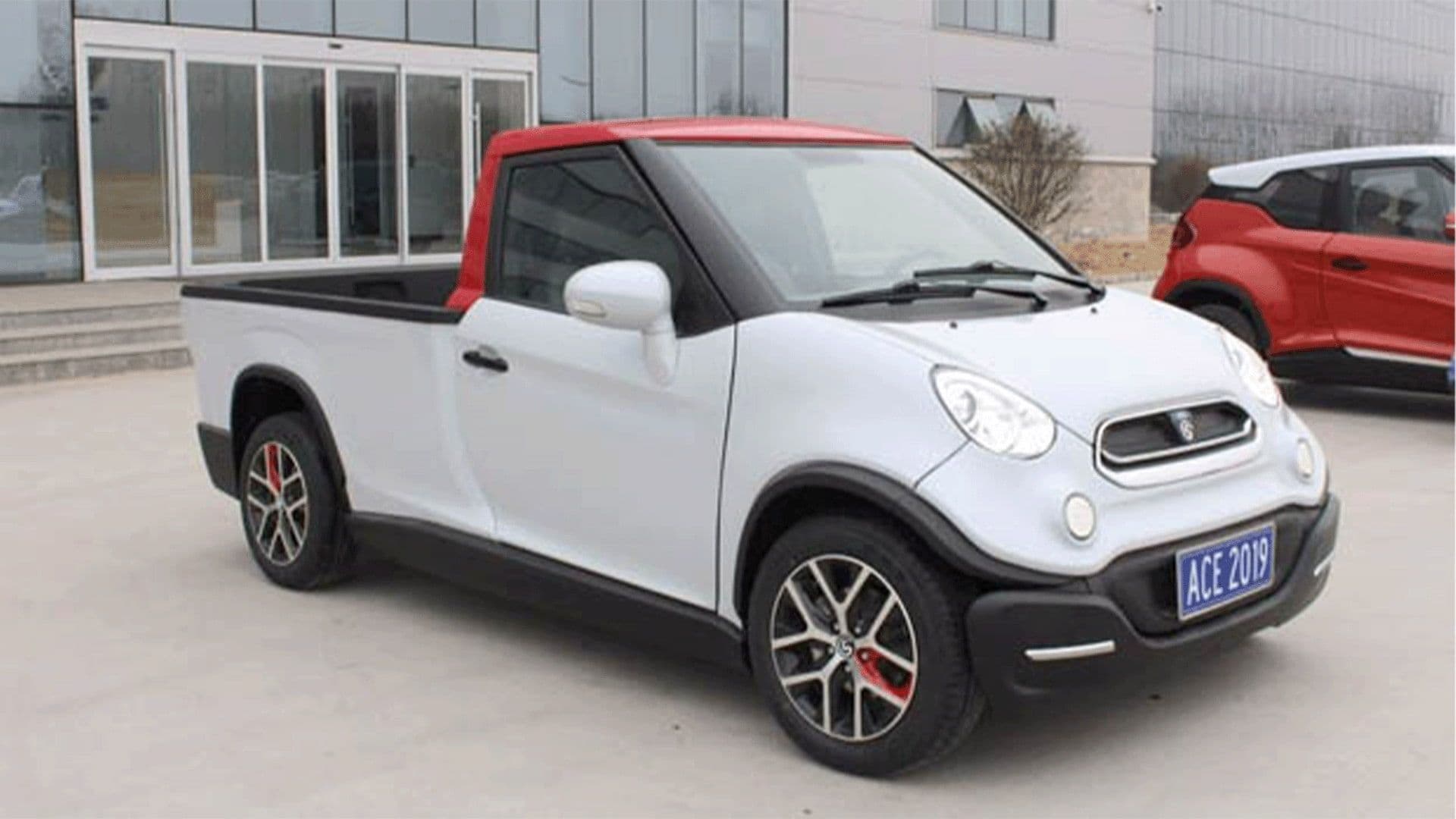 White Ace Yewt Model EA180T in front of a building beside a red car White Ace Yewt Model EA180T in front of a building beside a red car