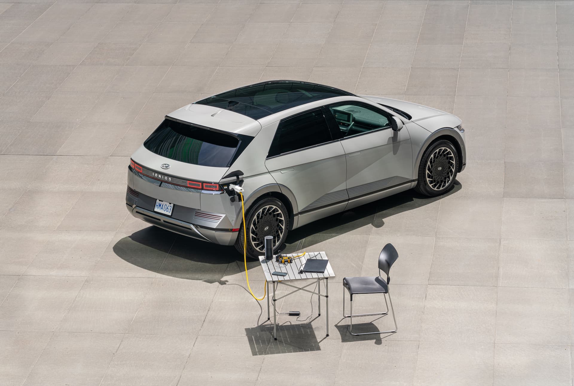 Matte Gravity Gold Hyundai Ioniq 5 discharging V2L into laptop and table Matte Gravity Gold Hyundai Ioniq 5 discharging V2L into laptop and table