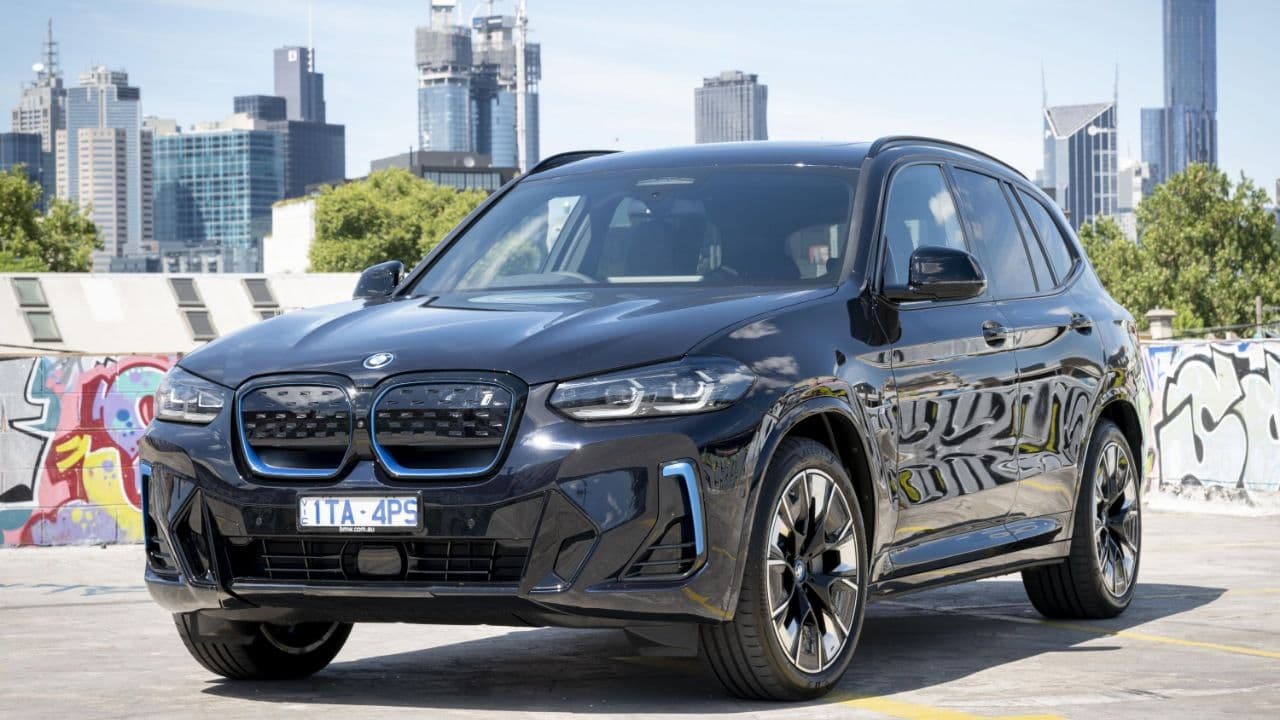 2024 BMW iX3 parked with city background 2024 BMW iX3 parked with city background