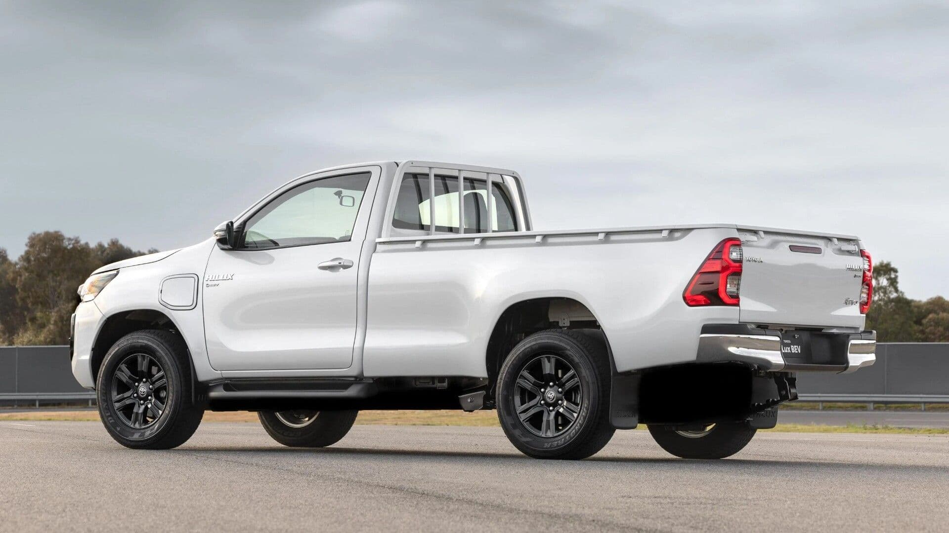 Electric Toyota HiLux in white side view in testing grounds Electric Toyota HiLux in white side view in testing grounds
