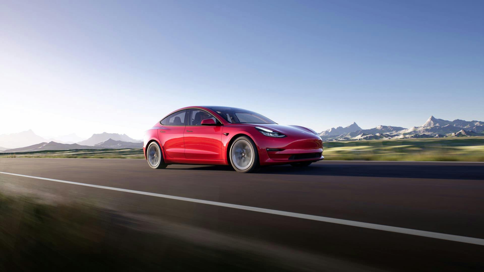 Red Tesla Model 3 driving