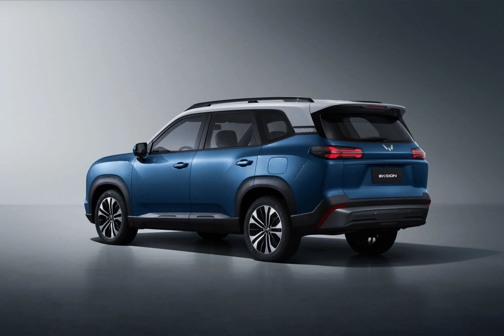 Blue Wuling Eksion SUV, rear three-quarter view in a studio Blue Wuling Eksion SUV, rear three-quarter view in a studio