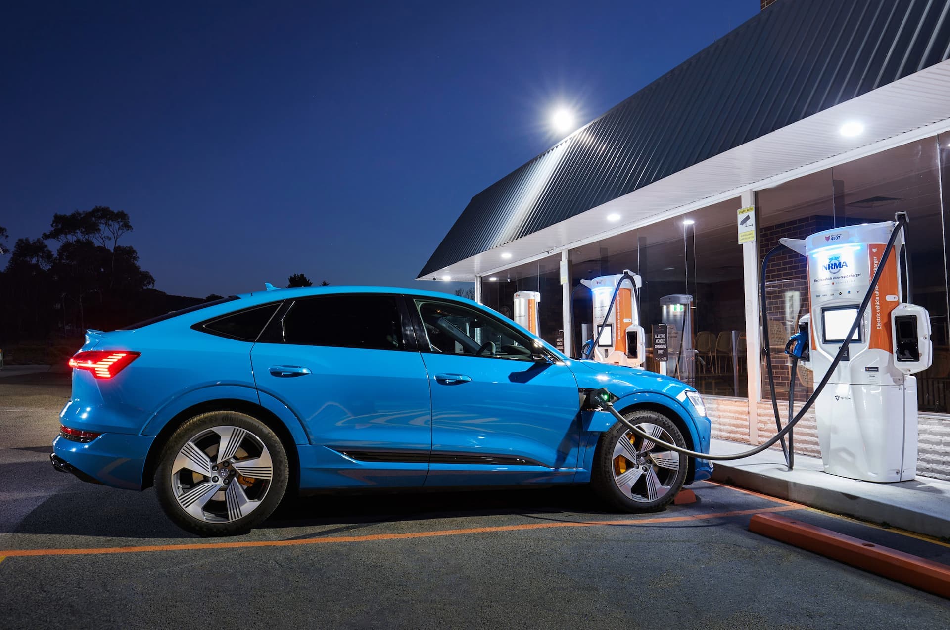 Blue Audi e-Tron Sportback charging at NRMA Chargefox DC ultra rapid charger night Blue Audi e-Tron Sportback charging at NRMA Chargefox DC ultra rapid charger night