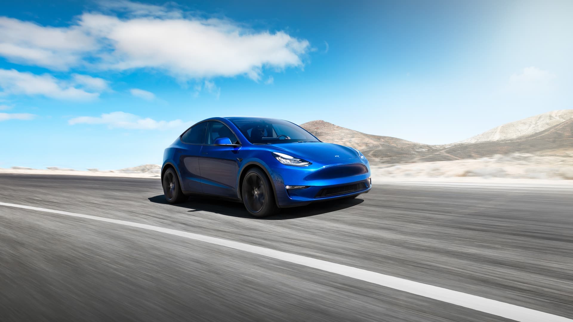 Blue Tesla Model Y driving Blue Tesla Model Y driving
