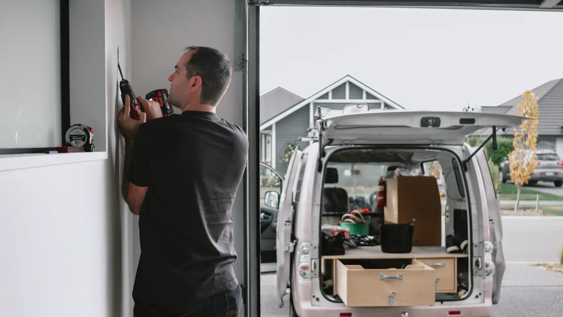 Electrician installing an EV charger on a wall Electrician installing an EV charger on a wall