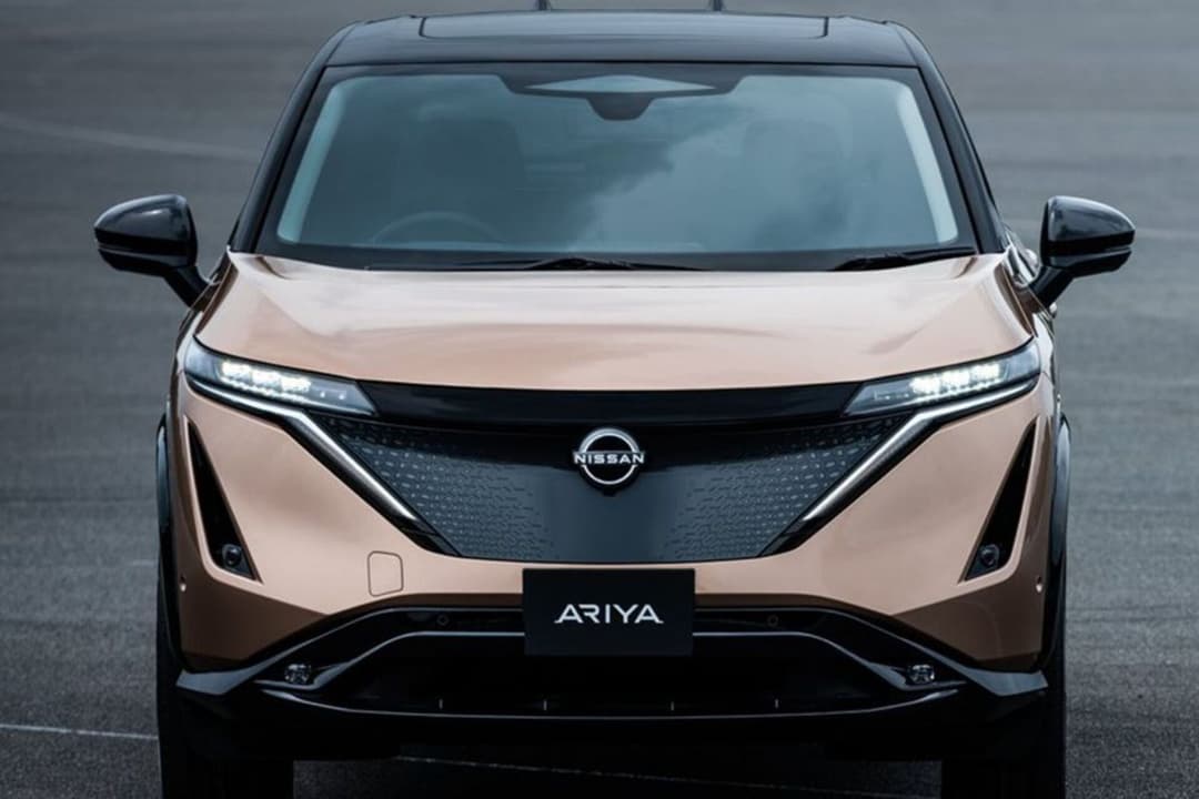 Nissan Ariya in gold and black front view parked on road Nissan Ariya in gold and black front view parked on road