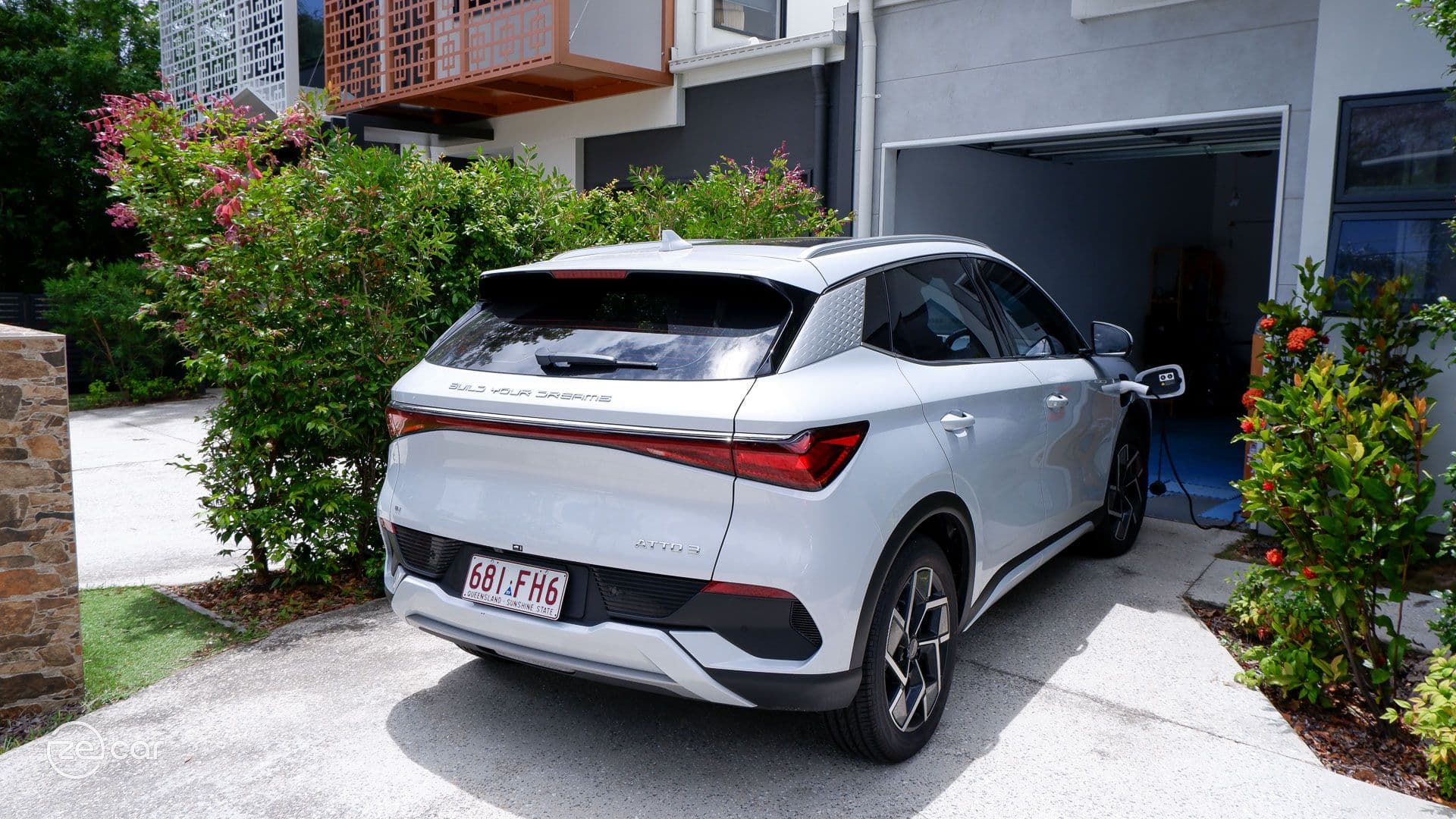 BYD Atto 3 charging in driveway during the day BYD Atto 3 charging in driveway during the day