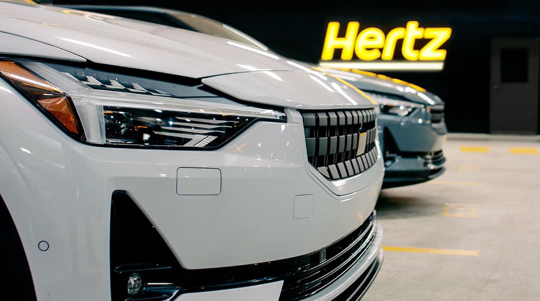 Two Polestar 2s parked in front of Hertz logo Two Polestar 2s parked in front of Hertz logo