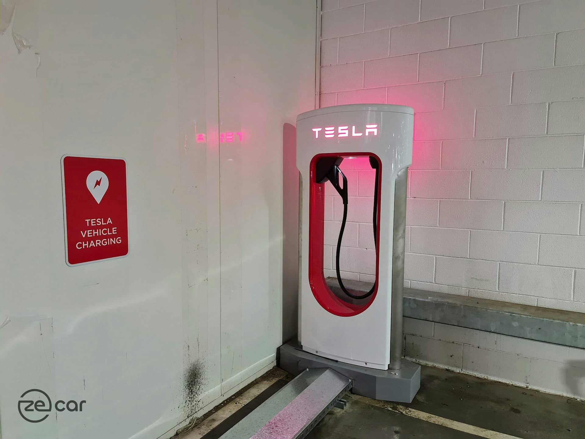 Toombul Tesla Supercharger stall with Tesla Vehicle Charging sign on the wall