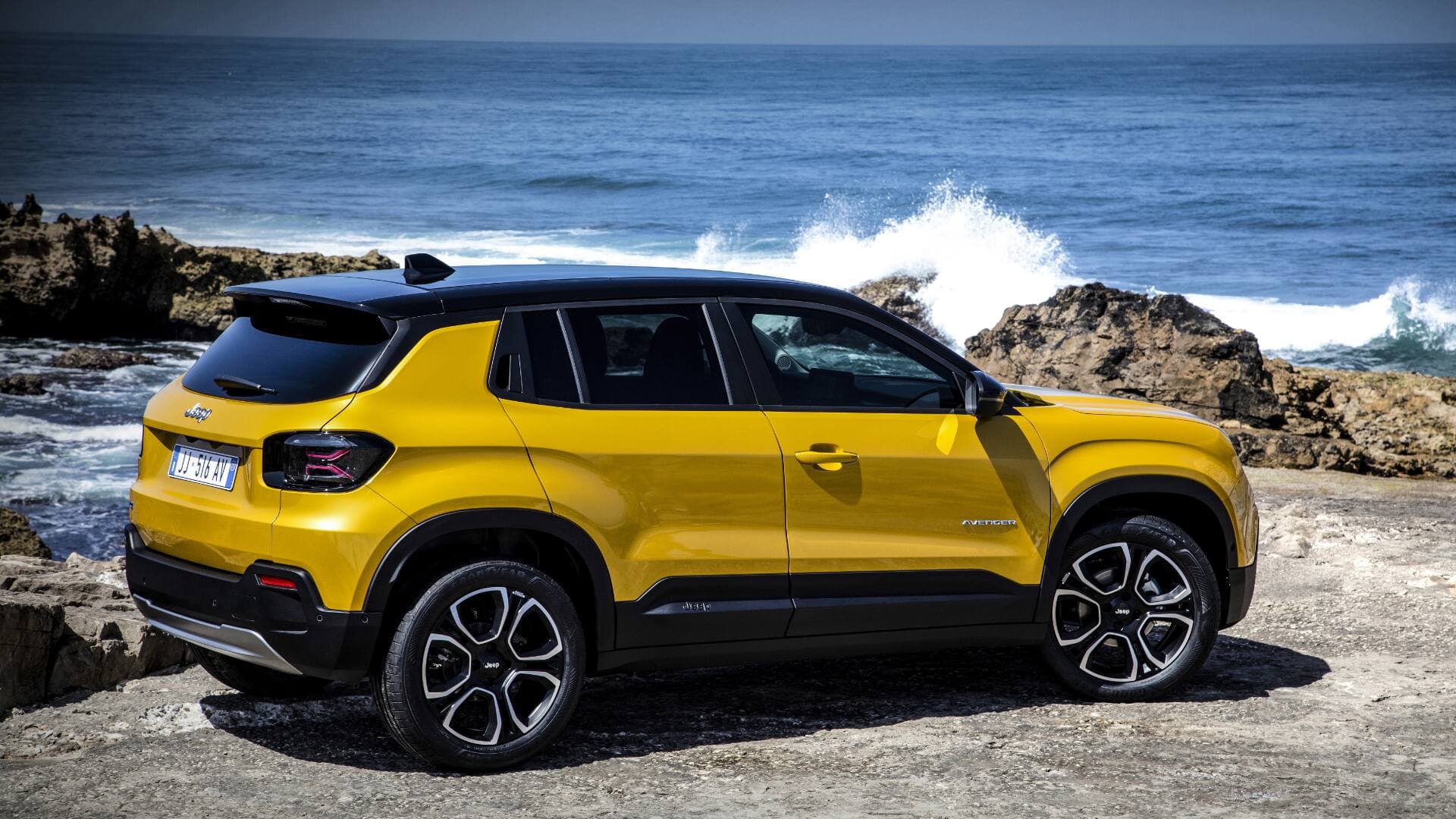 2025 Jeep Avenger in gold rear quarter view parked with sea background 2025 Jeep Avenger in gold rear quarter view parked with sea background