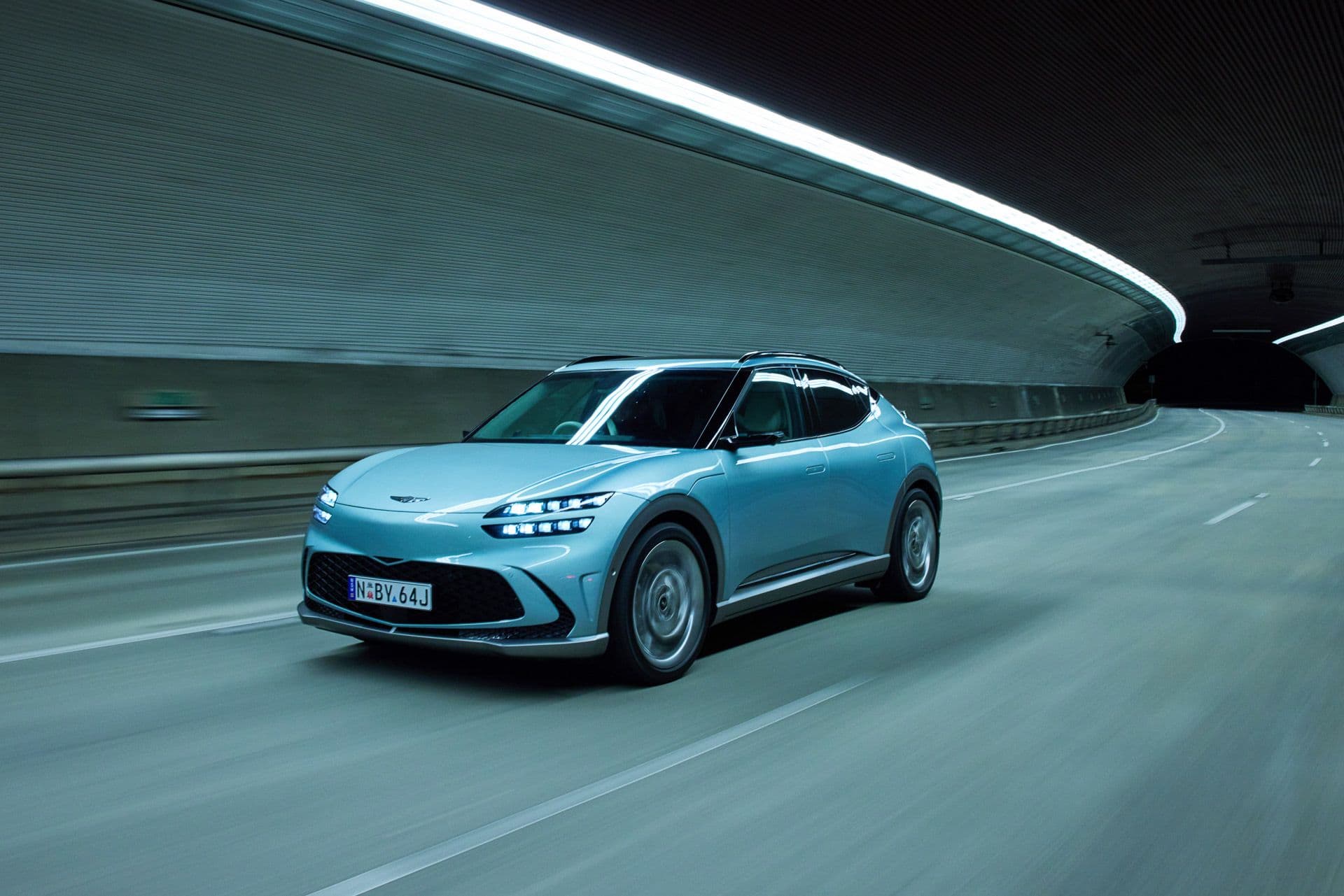 Blue Genesis GV60 driving in tunnel front view Blue Genesis GV60 driving in tunnel front view