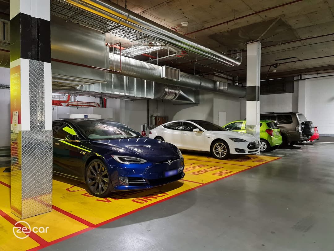 Blue Tesla Model S and white Tesla Model S Destination AC charging in carpark Blue Tesla Model S and white Tesla Model S Destination AC charging in carpark
