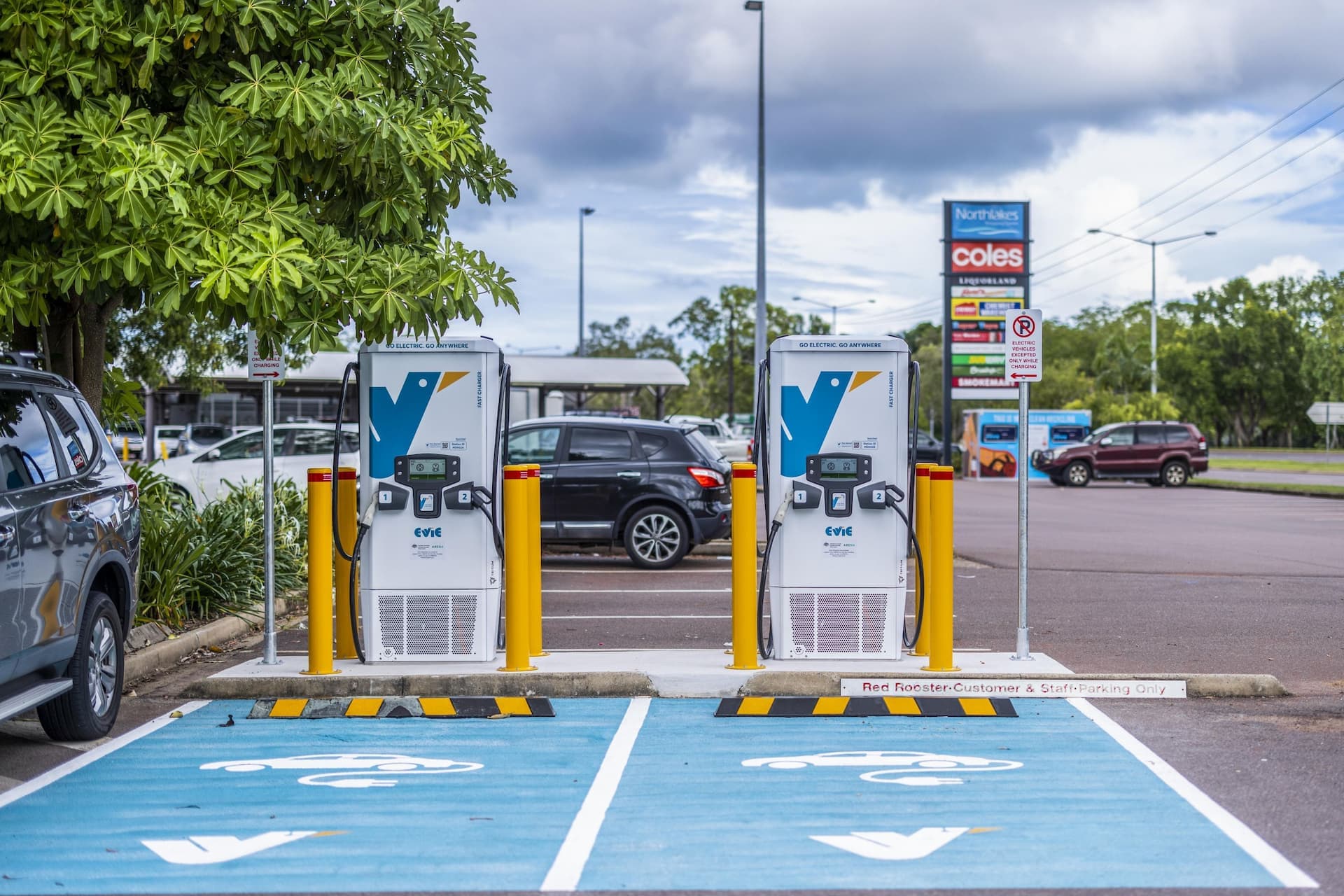 Two Evie Networks fast chargers in Darwin with teal painted charging spots in front of market area Two Evie Networks fast chargers in Darwin with teal painted charging spots in front of market area