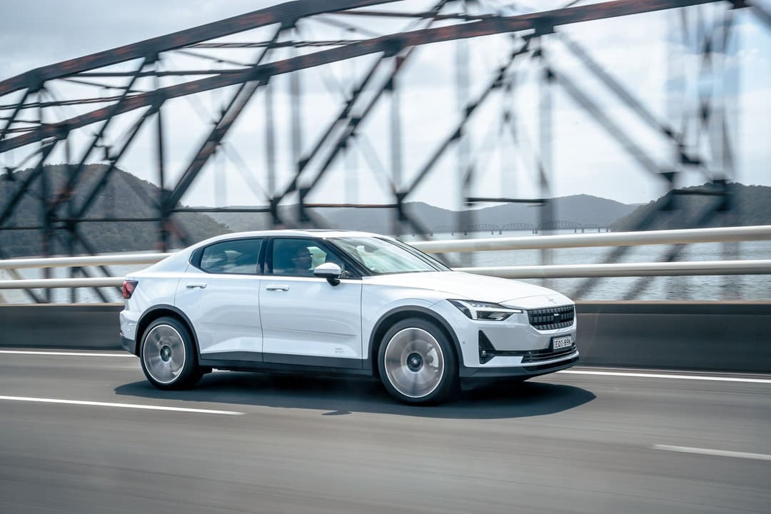 White Polestar 2 driving beside bridge White Polestar 2 driving beside bridge