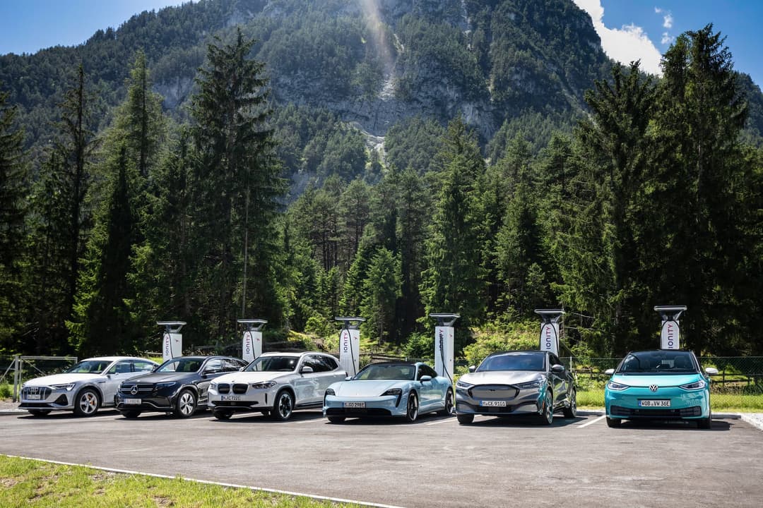 Electric cars charging at DC Ionity charging station in front of mountain Electric cars charging at DC Ionity charging station in front of mountain