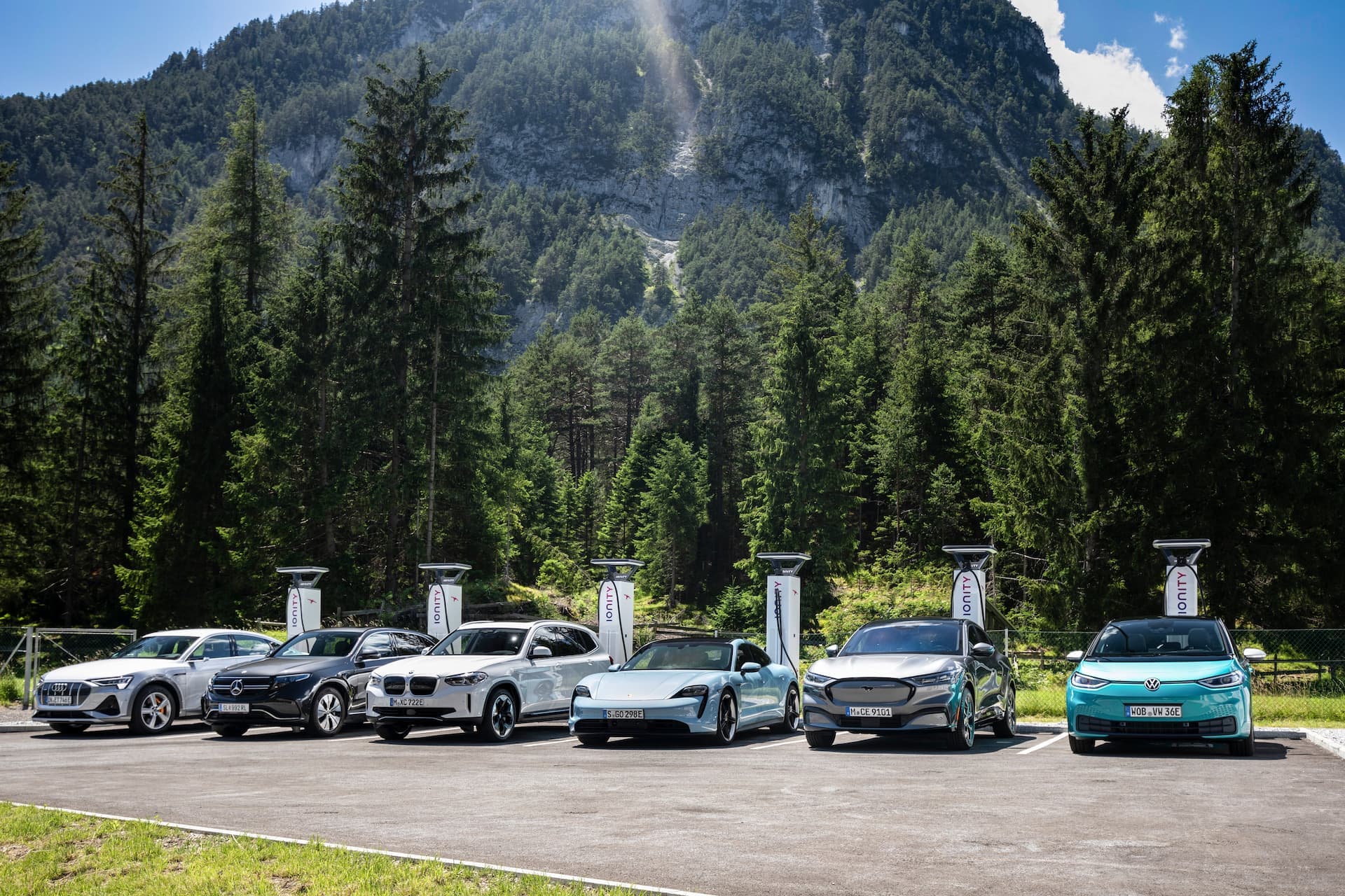 Electric cars charging at DC Ionity charging station in front of mountain Electric cars charging at DC Ionity charging station in front of mountain
