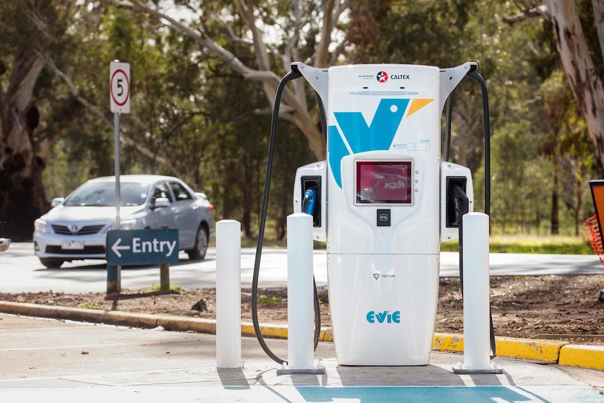 Evie Networks 350kW Tritium ultra rapid charger in front of 'entry' Ampol fuel station sign