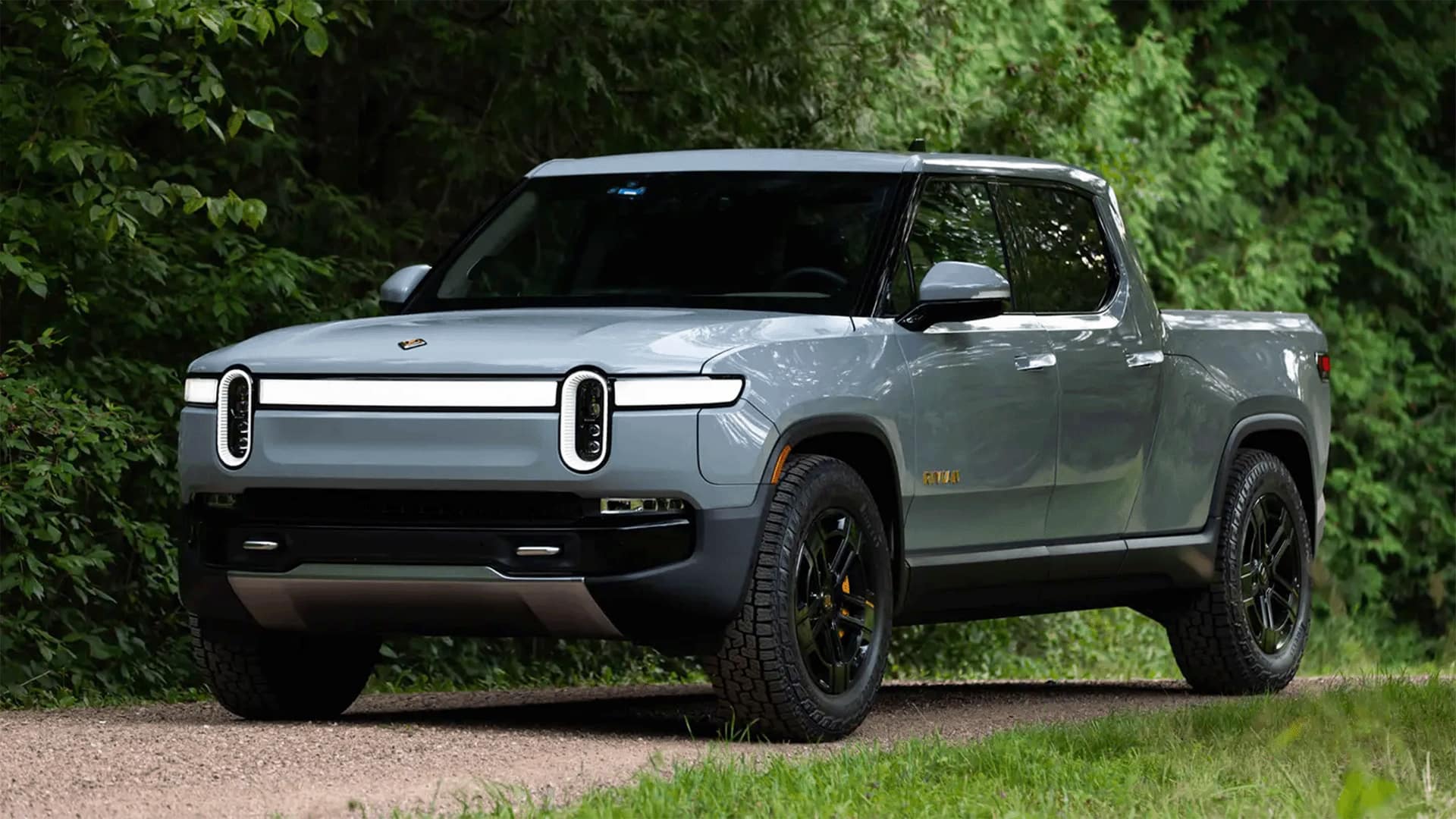 Gret Rivian R1T in off-road inside a forest background Gret Rivian R1T in off-road inside a forest background