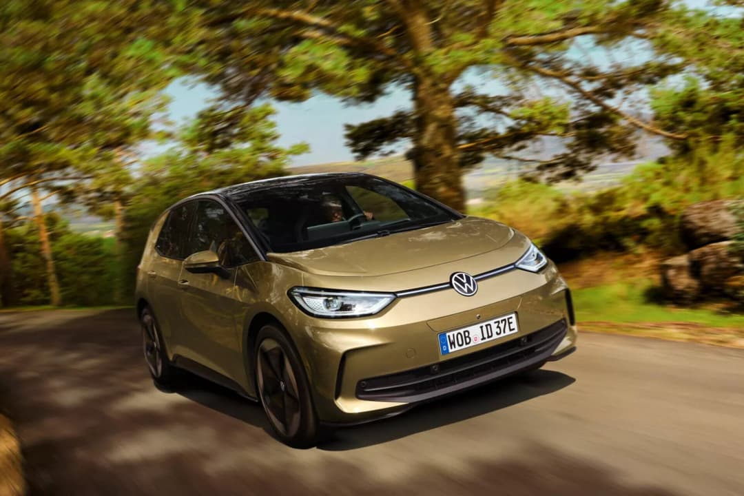 Volkswagen ID.3 in gold three quarter view driving on road Volkswagen ID.3 in gold three quarter view driving on road