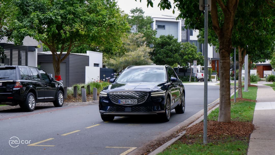 Genesis Electrified GV70 driving in suburban street Genesis Electrified GV70 driving in suburban street
