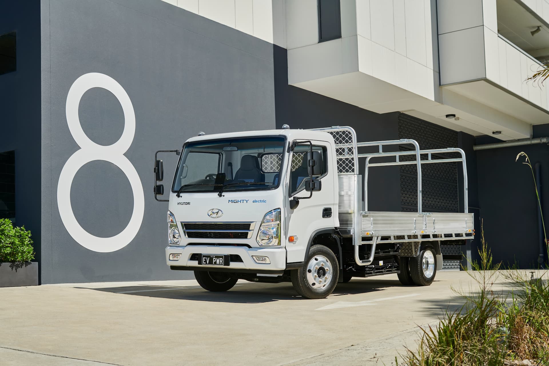 White Hyundai Mighty cab-chassis truck in front of '8' apartment symbol White Hyundai Mighty cab-chassis truck in front of '8' apartment symbol