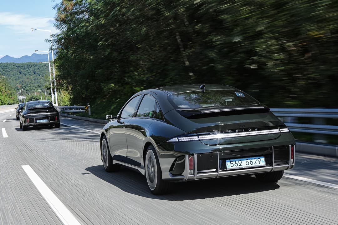 Dark green Hyundai Ioniq 6 driving behind black Ioniq 6 Dark green Hyundai Ioniq 6 driving behind black Ioniq 6