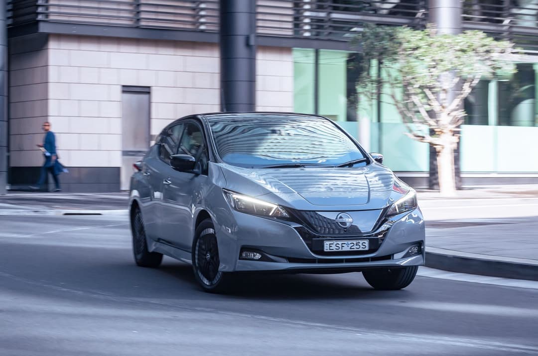 Grey 2023 Nissan Leaf driving in city Grey 2023 Nissan Leaf driving in city