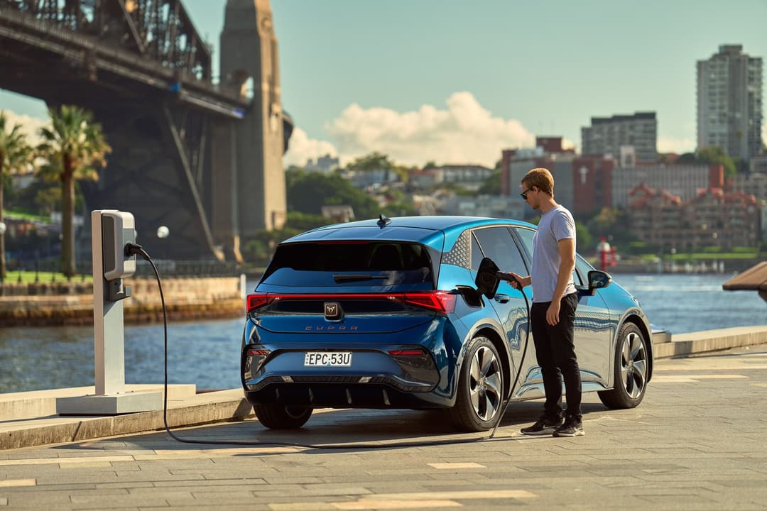 Man plugs in charger into the Cupra Born BEV in Sydney Circular Quay Man plugs in charger into the Cupra Born BEV in Sydney Circular Quay