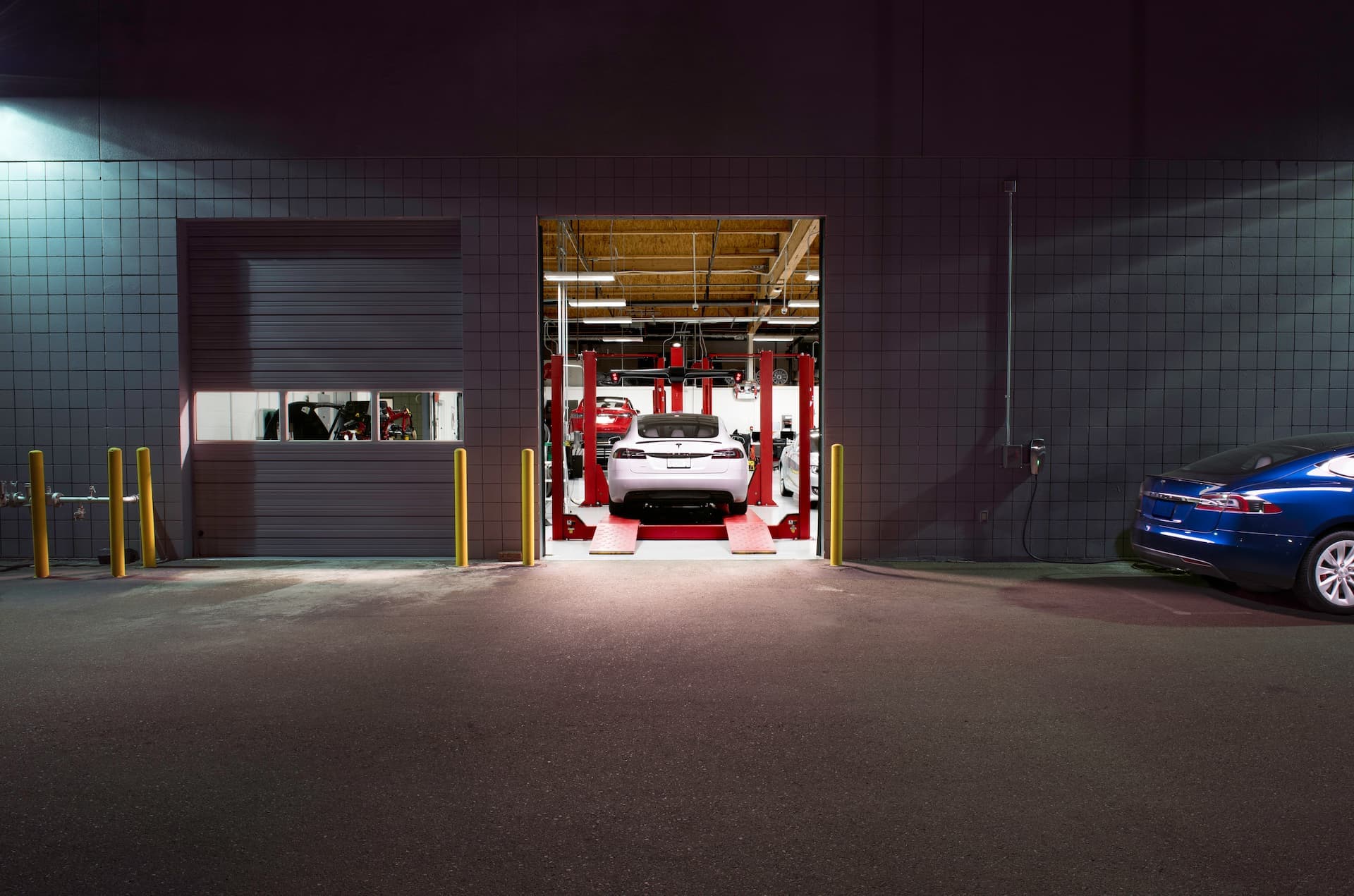 Tesla Model S in servicing workshop at night Tesla Model S in servicing workshop at night