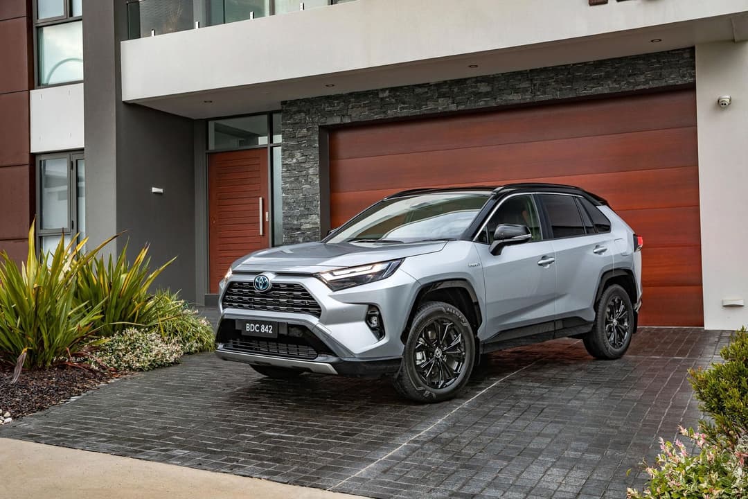 Silver Toyota RAV4 Hybrid parked in front of house driveway Silver Toyota RAV4 Hybrid parked in front of house driveway