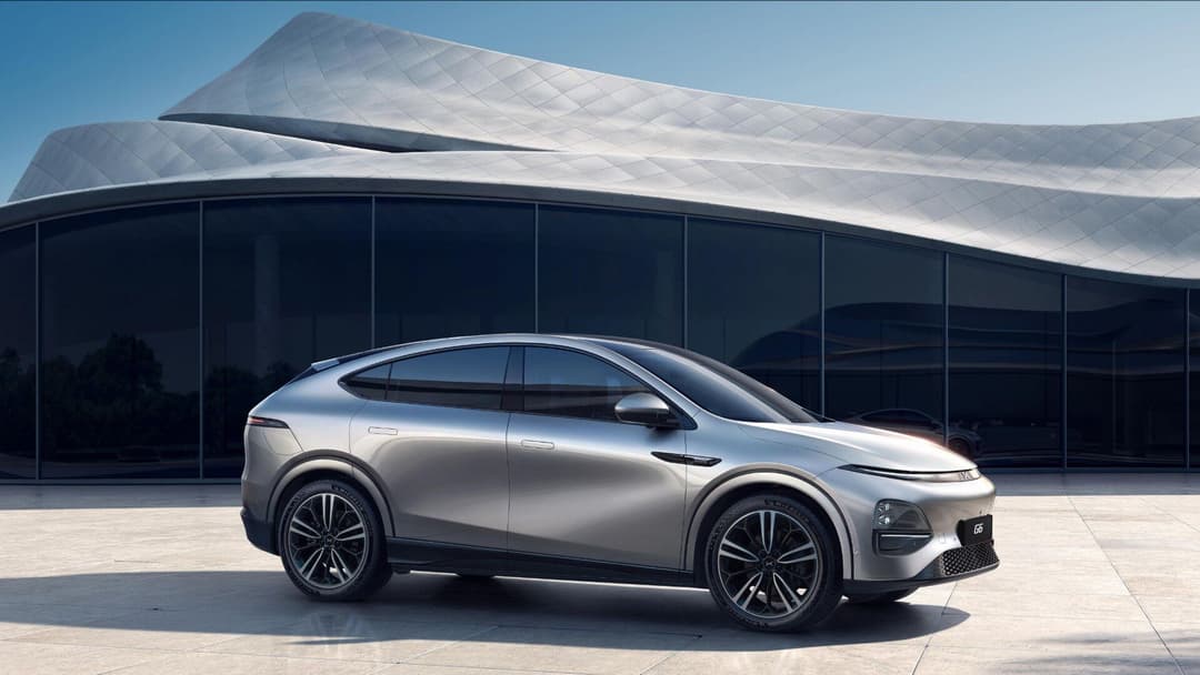 Xpeng G6 in grey side view parked with building background Xpeng G6 in grey side view parked with building background