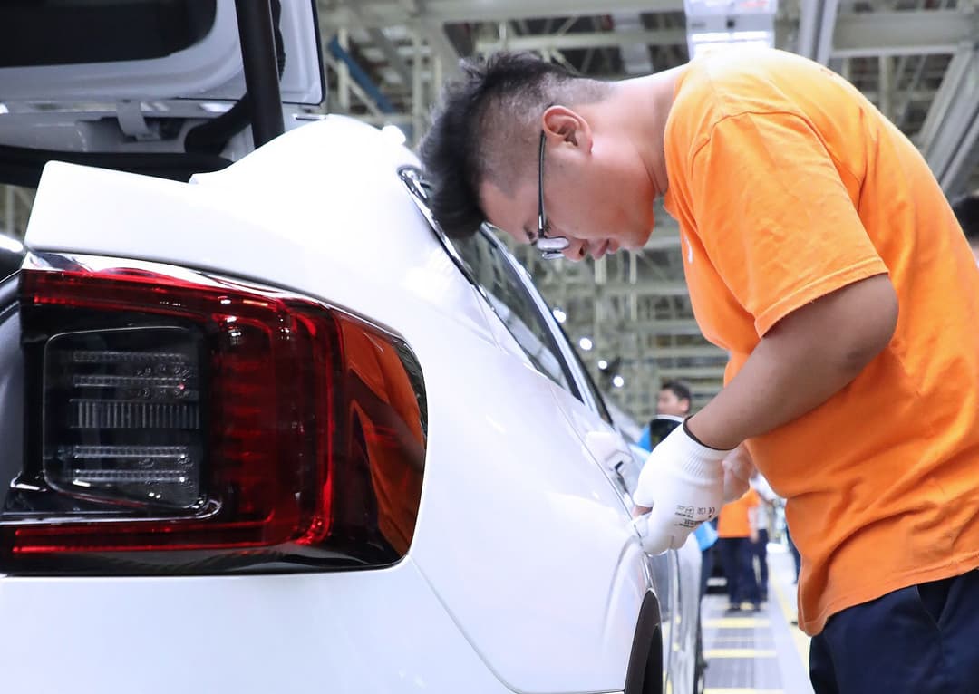 Man touching Polestar 2 in factory Man touching Polestar 2 in factory