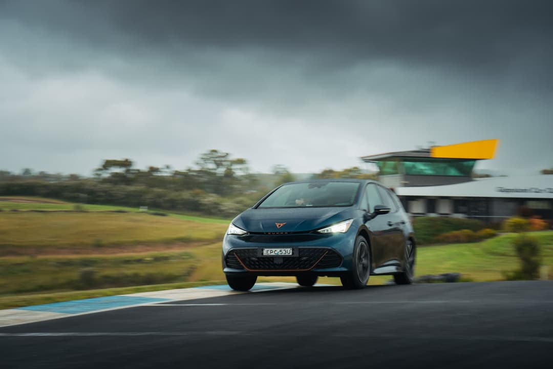 Blue Cupra Born driving on track Blue Cupra Born driving on track