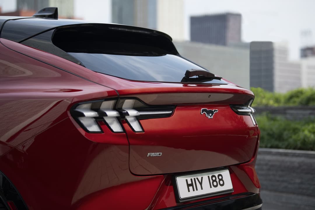 Rear-end of red Ford Mustang Mach-E with Mustang horse badge Rear-end of red Ford Mustang Mach-E with Mustang horse badge