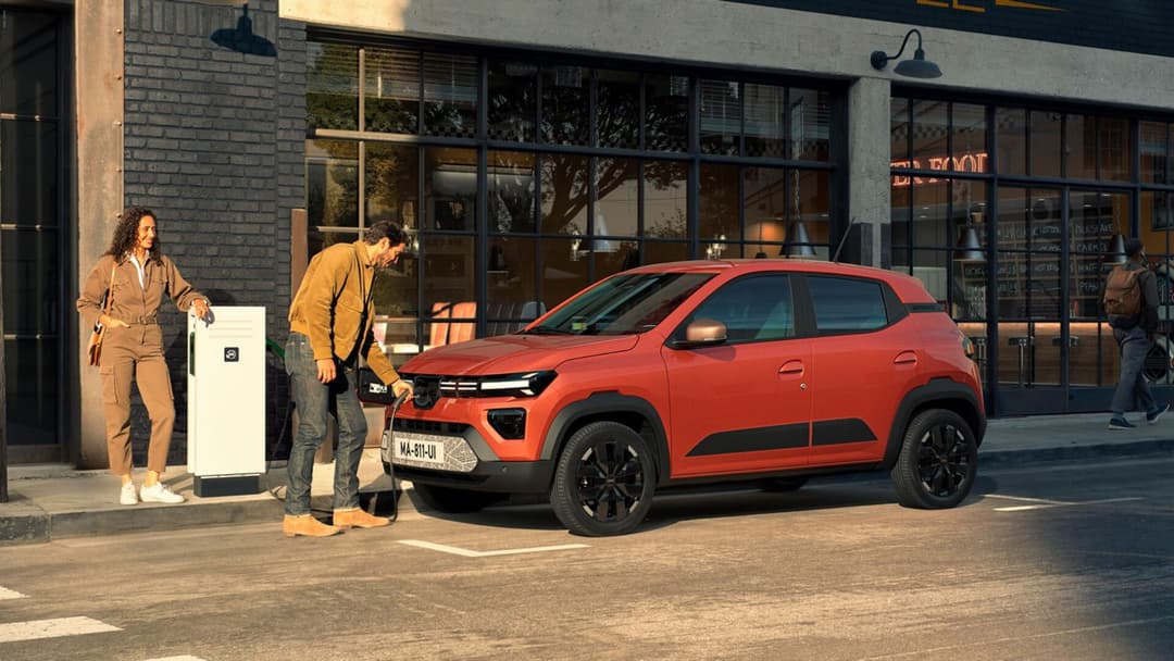 Dacia Spring in orange public charging side view Dacia Spring in orange public charging side view